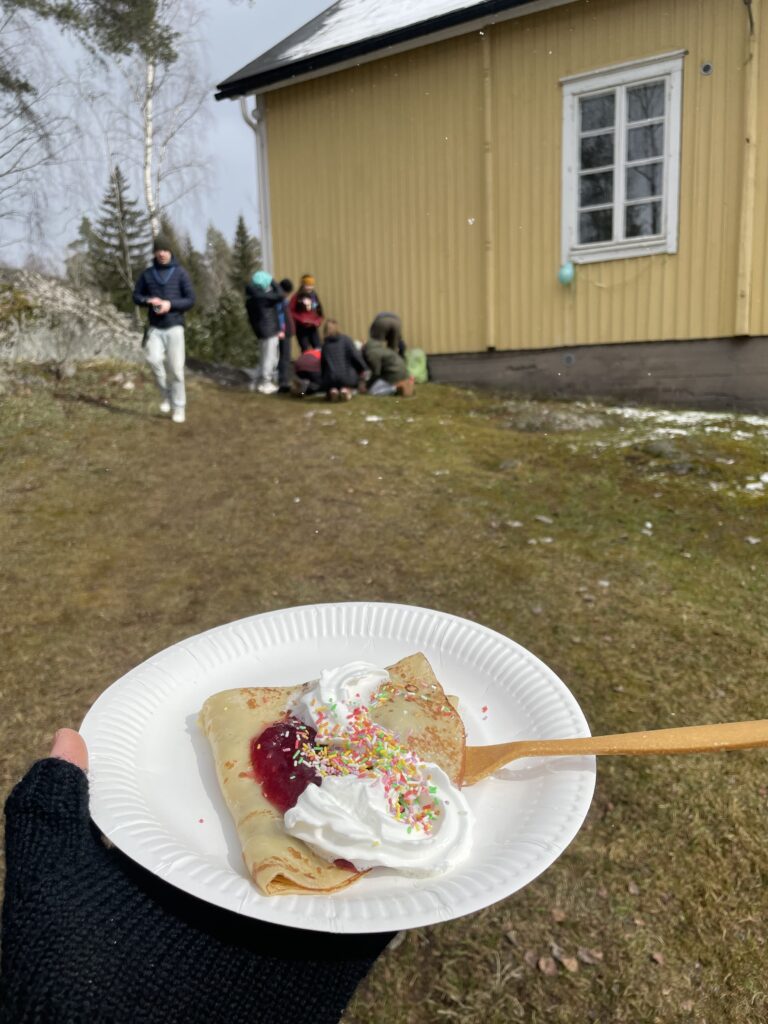Henkilö pitää kädessää lautasellista lettuja, joilla kermavaahtoa ja strösseleitä